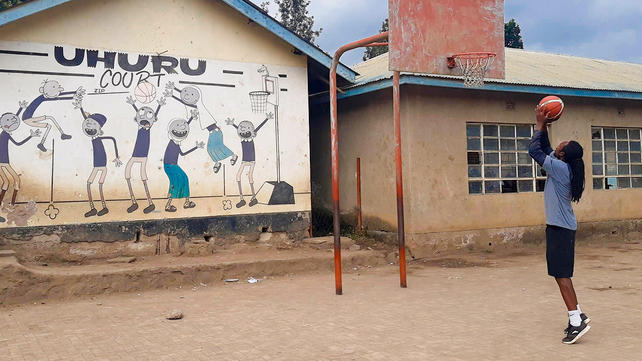 Phabian Mjarifu, Projektmentor des „Pamoja Basketball Project“, wirft einen Korb in einer Grundschule in Tansania.