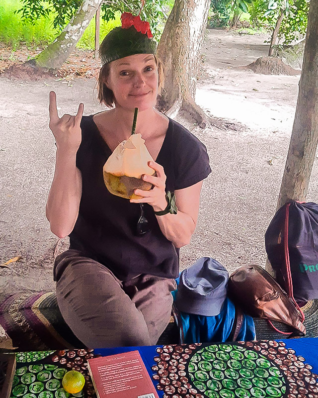 Nicola takes a break, reads a book and drinks coconut water from a fresh coconut with a straw.