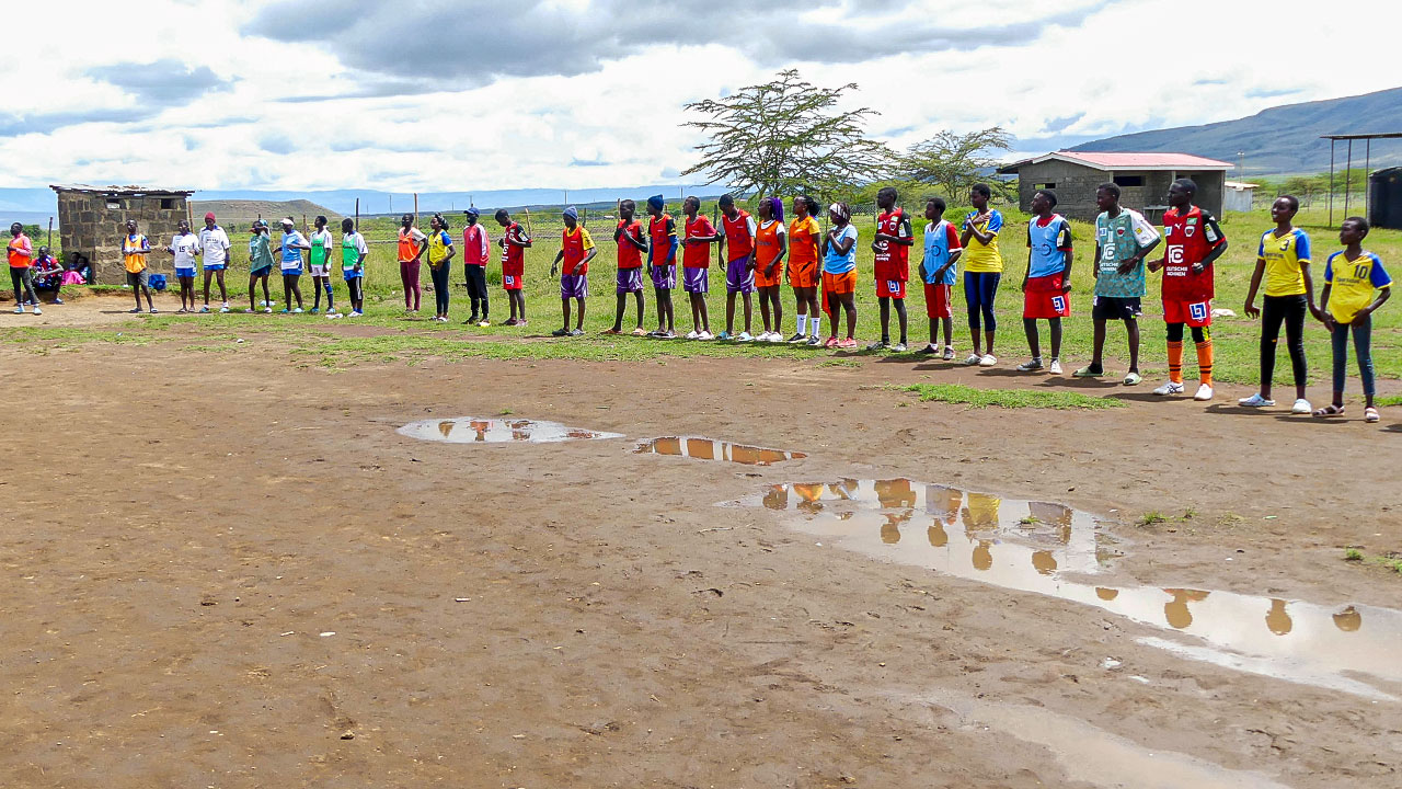 Players from a Kenyan youth football team line up on the sidelines of a tournament organised by a social sports project, waiting for their turn to play.